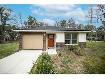 Charming home with a brick facade, new roof, light tan siding and manicured lawn at 2482 County Road 423, Lake Panasoffkee, FL 33538