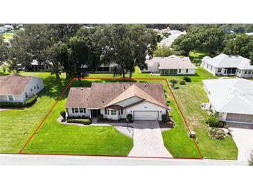 Single-story house with a large backyard and paved driveway, situated in a quiet residential neighborhood at 6410 Tildon Ct, Leesburg, FL 34748