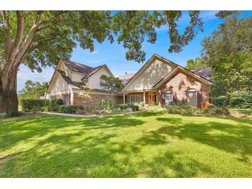 Charming two-story home with a brick facade, well-manicured lawn, and mature trees offering shade at 2602 Tryon Pl, Windermere, FL 34786