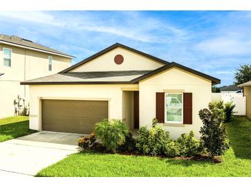 Charming single-story home with a neutral color palette, attached garage, and a well-maintained lawn, creating a welcoming curb appeal at 555 Meadow Pointe Dr, Haines City, FL 33844