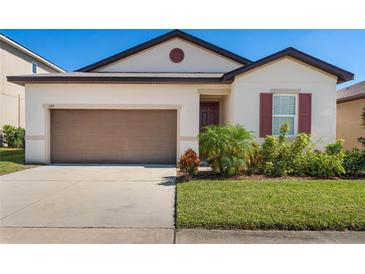 House exterior featuring a two-car garage and manicured lawn at 555 Meadow Pointe Dr, Haines City, FL 33844