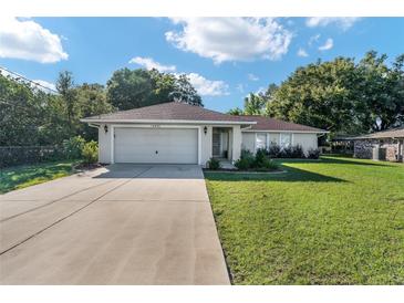 Single-story house with attached garage and well-manicured lawn at 14490 Se 96Th Ter, Summerfield, FL 34491