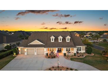 Charming home with a three-car garage, covered porch, and manicured landscaping, ideal for suburban living at 4049 Nostalgia Ter, The Villages, FL 32163