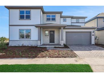 Beautiful two-story home with a well-manicured lawn and an attached two-car garage at 6616 Quest St, St Cloud, FL 34771