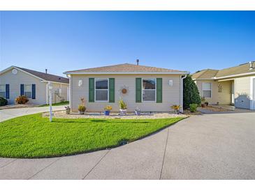 Well-maintained home with green shutters and a manicured lawn at 547 Richburg St, The Villages, FL 32162