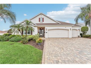 Beautiful two-story home with a three-car garage, landscaping, and a paved driveway at 1596 Birmingham Ter, The Villages, FL 32162