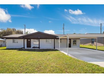 Charming single-story home featuring a carport, covered entry, black accents, and a well-maintained lawn at 2030 Leisure Dr, Winter Haven, FL 33881