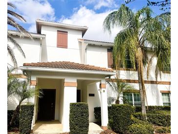 Charming two-story townhome with a tile roof, brown shutters, and meticulously maintained landscaping at 4847 Clock Tower Dr, Kissimmee, FL 34746