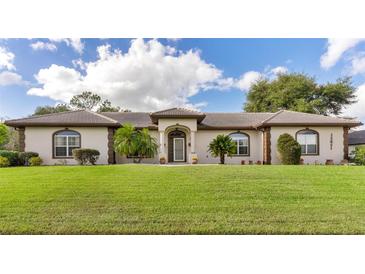 One-story home with brown roof and landscaping at 6178 Spinnaker Loop, Lady Lake, FL 32159