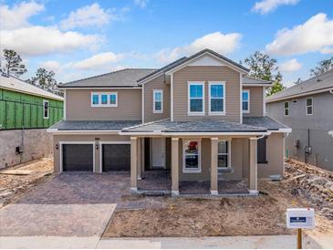 Two-story house with brown double doors and a stone driveway at 14421 Crest Palm Ave, Windermere, FL 34786