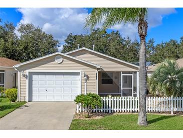 Charming single-story home featuring a two-car garage, screened-in porch, and manicured front lawn at 17478 Se 77Th Sycamore Ave, The Villages, FL 32162