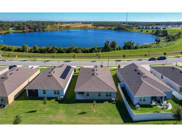 Aerial view of backyards on homes near a lake showcasing green lawns and serene water views at 1089 Fig St, Tavares, FL 32778