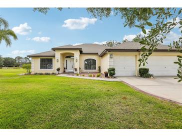 Well-maintained single-story home with a manicured lawn and a three-car garage at 36729 Alaqua Ct, Eustis, FL 32736