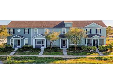 Charming townhomes feature colorful exteriors, inviting front porches and lush landscaping, creating a welcoming community atmosphere at 561 Juniper Springs Dr, Groveland, FL 34736