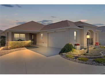 Charming single story home with well-maintained landscaping, two-car garage, and neutral color palette at 3469 Melbourne Ln, The Villages, FL 32163