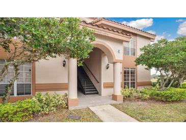 Exterior view of condo building with stairs and landscaping at 4852 Normandy Pl # 101, Orlando, FL 32811