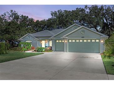 Well-maintained house with a two-car garage and landscaped front yard at 9811 Pepper Tree Pl, Wildwood, FL 34785