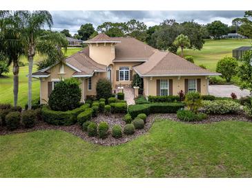 Gorgeous home featuring lush landscaping, manicured lawn, and a welcoming entrance at 39539 Harbor Hills Blvd, Lady Lake, FL 32159