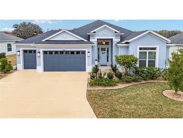 Beautiful one-story home with gray and blue exterior, two-car garage, and landscaped yard at 3606 Adamsville Ave, The Villages, FL 32163
