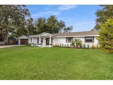 Charming single-story home features a manicured lawn and well-maintained landscaping and a two car garage at 1001 Michelle Ct, Tavares, FL 32778