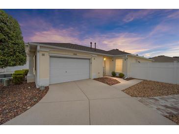 House exterior at dusk showing a garage and landscaping at 17159 Se 78Th Crowfield Ave, The Villages, FL 32162