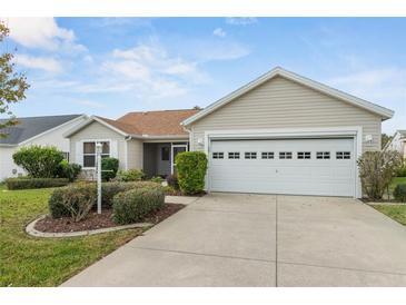 Charming single-story home featuring a well-manicured front yard and an attached two-car garage at 17848 Se 87Th Bourne Ave, The Villages, FL 32162