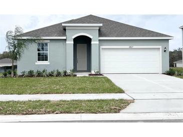 Charming single Gathering home featuring a two car garage, neutral paint, manicured lawn, and simple landscaping at 2827 Supermarine Rd, Tavares, FL 32778