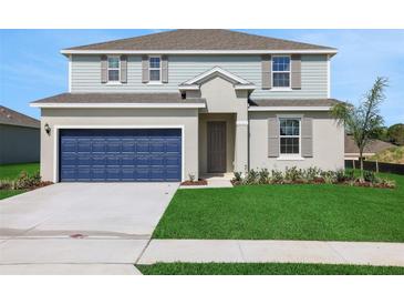 Charming two-story home with a blue garage door and well-maintained lawn at 2833 Supermarine Rd, Tavares, FL 32778
