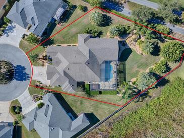 Aerial view of a luxurious home with a pool and landscaped yard at 1877 Quailey Ct, The Villages, FL 32163