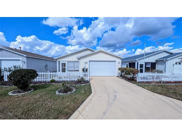 Charming single-story home with a well-maintained front yard, white picket fence, and driveway at 3449 Roanoke St, The Villages, FL 32162