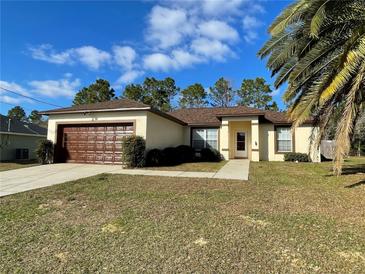 One-story house with brown garage door and landscaped lawn at 61 Fir Dr, Ocala, FL 34472