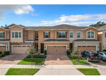 Two-story townhome with two-car garage and landscaped front yard at 765 Walkers Grove Ln, Winter Garden, FL 34787