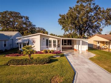 Single-story home with carport and landscaped yard at 1121 Paradise Dr, Lady Lake, FL 32159