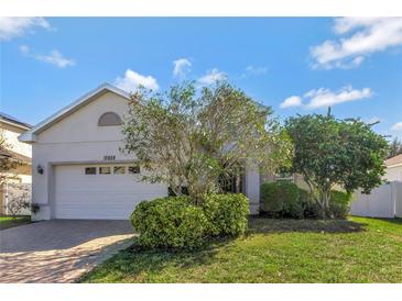 Attractive single-story home with a two-car garage and well-manicured lawn at 15828 Starlite St, Clermont, FL 34714
