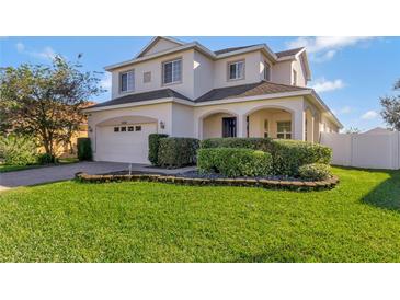Two-story house with a white exterior, landscaping, and a two-car garage at 15836 Starlite St, Clermont, FL 34714