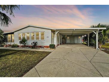 Single-wide manufactured home with carport and well-maintained lawn at 1701 Magnolia Ave, The Villages, FL 32159