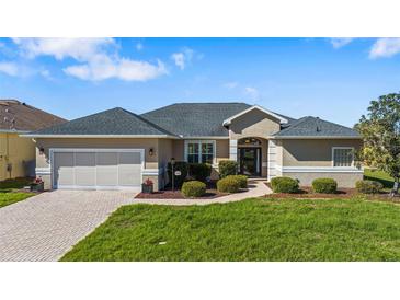 Charming single-story home featuring a well-manicured lawn and a welcoming entrance at 17350 Se 116Th Court Rd, Summerfield, FL 34491