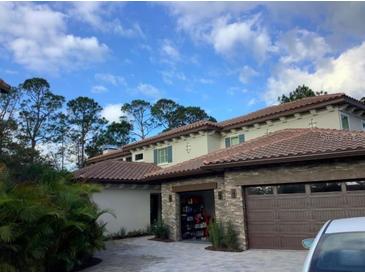 Two-story home with stone accents and a three-car garage at 10122 Royal Island Ct, Orlando, FL 32836