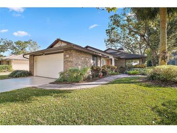 Brick house with a well-manicured lawn and attached garage at 107 Waterwood Dr, Yalaha, FL 34797