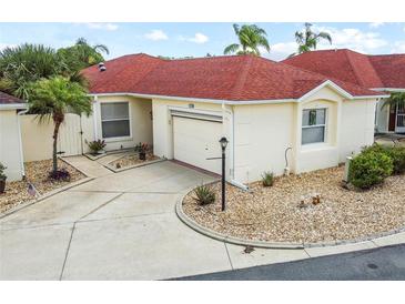 Charming single-story home featuring a red roof, well-maintained landscaping, and an attached garage at 1330 Lajolla Cir, The Villages, FL 32159