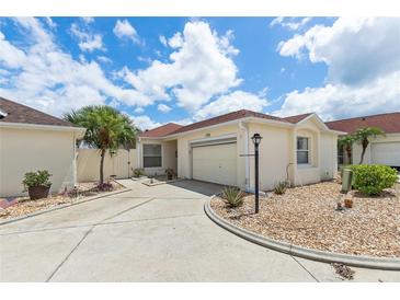 Charming single-story home with a well-manicured lawn, a concrete driveway, and an attached garage at 1330 Lajolla Cir, The Villages, FL 32159
