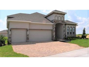Two-story house with two-car garage and brick accents at 2137 Sunshine Peak Dr, Minneola, FL 34715