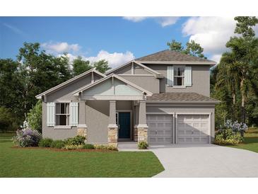 Two-story house with gray siding, light-colored garage doors, and landscaping at 2252 Juniper Berry Dr, Minneola, FL 34715
