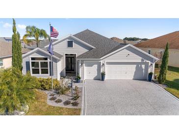 Two-story house with a large driveway and landscaped yard at 3259 Markward Dr, The Villages, FL 32163