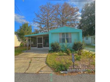 Quaint teal mobile home with mature trees and a spacious yard at 1005 Oakland St. St, Tavares, FL 32778