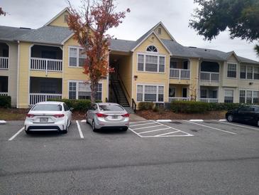 Two-story yellow apartment building with ample parking at 1075 S Hiawassee Rd # 911, Orlando, FL 32835