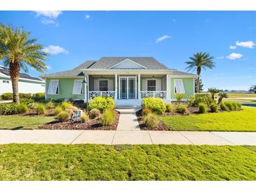 Charming green house with white accents and a welcoming porch at 1107 Sugar Loaf Key Loop, Lady Lake, FL 32159