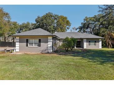 Gray house with a gray roof, white columns, and black shutters at 1209 Elysium Blvd, Mount Dora, FL 32757