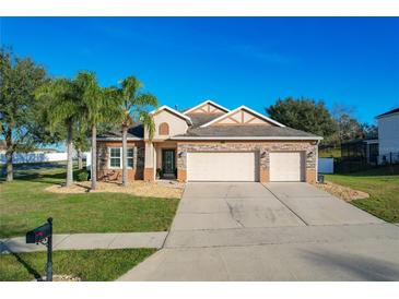 Attractive two-story house with three-car garage and palm trees at 12532 Hammock Pointe Cir, Clermont, FL 34711