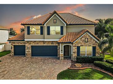 Two-story house with stone accents and a three-car garage at 17889 Gourd Neck Loop, Winter Garden, FL 34787